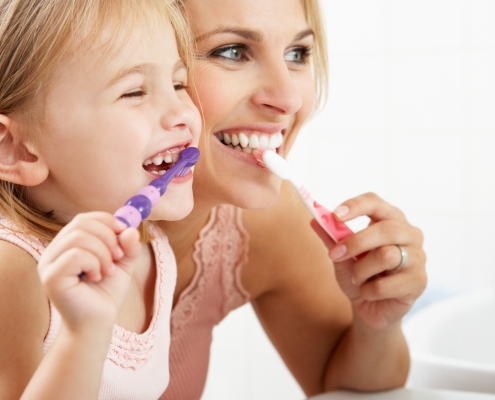 Mother and Daughter Brushing Teeth